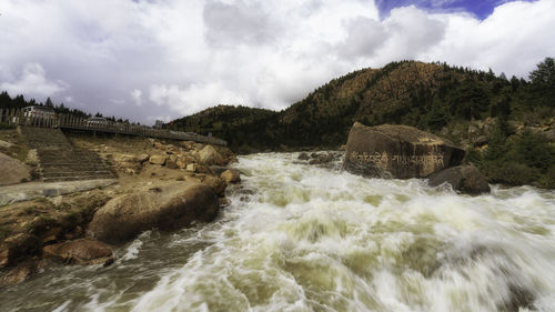 Scenic view of river flowing against sky