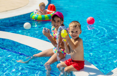 High angle view of boy playing with toys at poolside