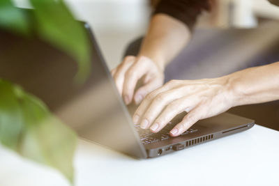 Young woman working from home, freelancer job concept, day light dynamic workplace.