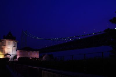 Illuminated bridge against blue sky