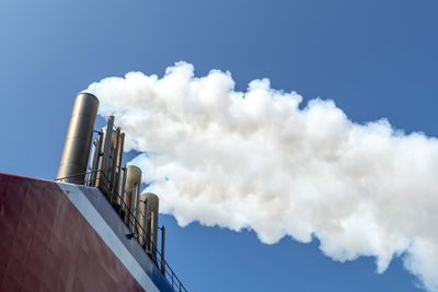 Thick white smoke billows from the chimneys of a ferry to england
