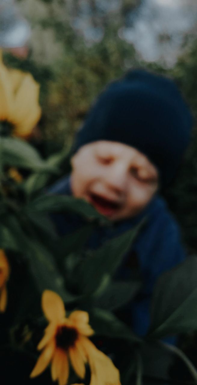 child, flower, yellow, plant, childhood, portrait, one person, nature, smiling, baby, flowering plant, day, clothing, front view, men, emotion, happiness, outdoors, close-up, innocence, leaf, toddler, headshot, autumn, focus on foreground, casual clothing, looking at camera, hat, plant part, freshness, standing, looking, growth, waist up, human eye, person, holding