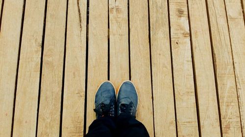 Low section of person standing on boardwalk