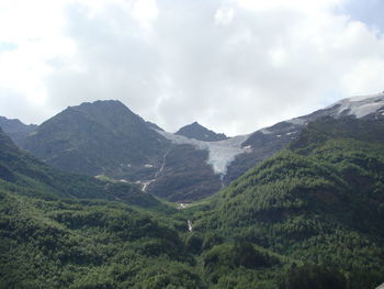 Scenic view of mountains against cloudy sky