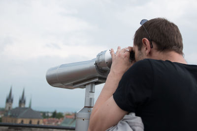 Man looking through coin-operated binoculars