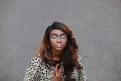 Young woman with eyes closed standing on street