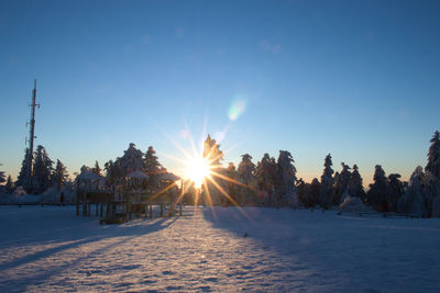 Scenic view of snow covered land against sky at sunset