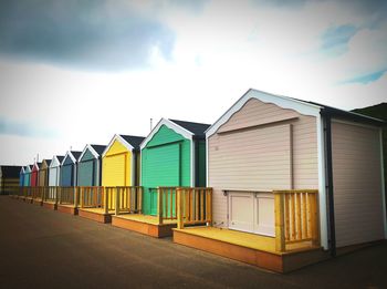 Houses on beach by building against sky