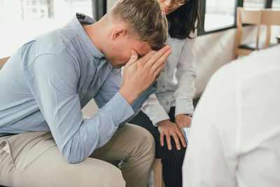 Consultant talking to couple sitting on chairs