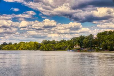 Scenic view of river against cloudy sky