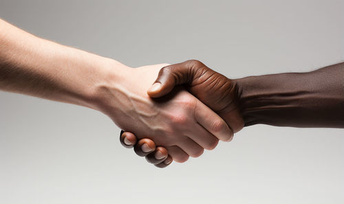 Cropped image of couple holding hands against white background