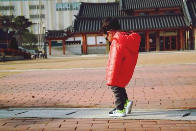 Side view of boy walking on footpath