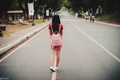 Rear view of women walking on road