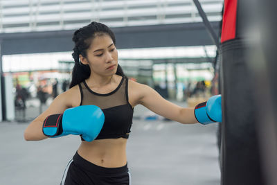 Young woman practicing boxing in gym