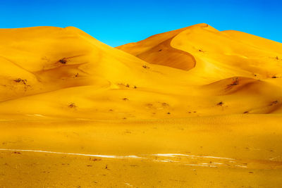 Scenic view of desert against blue sky