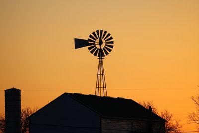 Low angle view of silhouette house against sky during sunset