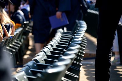 People by seats at webster university during graduation ceremony