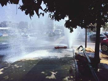 Water fountain in city against sky