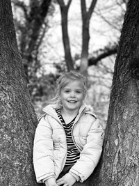 Portrait of smiling girl on tree trunk