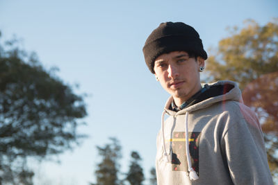 Portrait of young man standing against sky