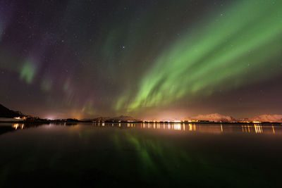 Scenic view of sea against aurora borealis at night