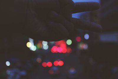 Close-up of hand with defocused lights in background