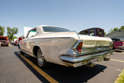 Vehicles on road against sky in city