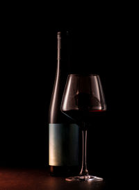 Wine glass on table against black background