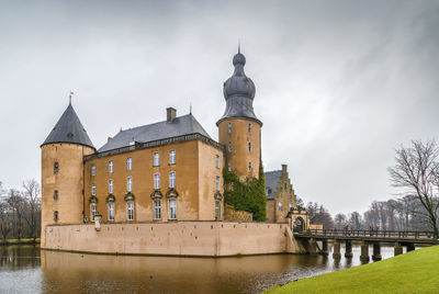 Building against sky with river in foreground