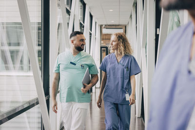 Multiracial male and female hospital staff walking in corridor