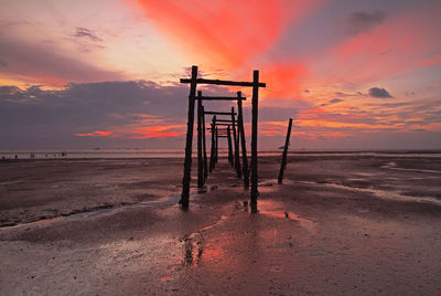 Lifeguard hut on beach against sky during sunset