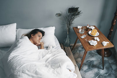 High angle view of woman lying on bed at home