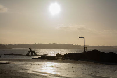 Silhouette person on beach against sky during sunset