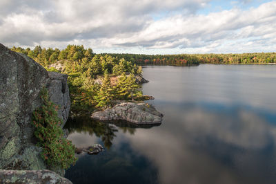 View of calm countryside lake against clouds