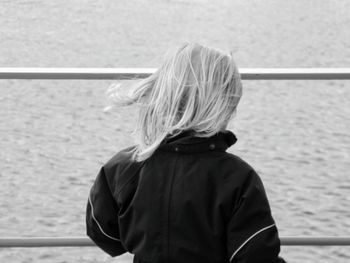 Rear view of girl standing against sea