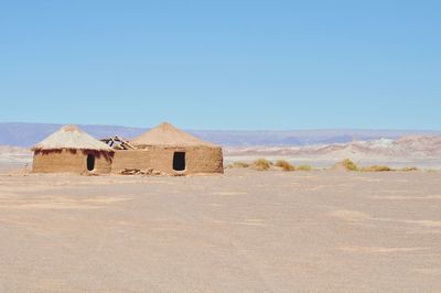 Built structure on desert against clear blue sky