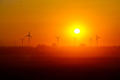 Silhouette of wind turbines at sunset