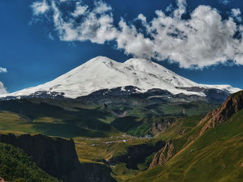 Scenic view of snowcapped mountains against cloudy sky