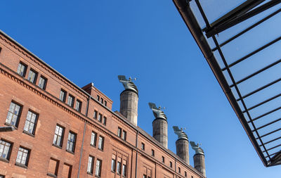 Low angle view of buildings against clear blue sky