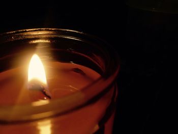 Close-up of lit candle in dark room