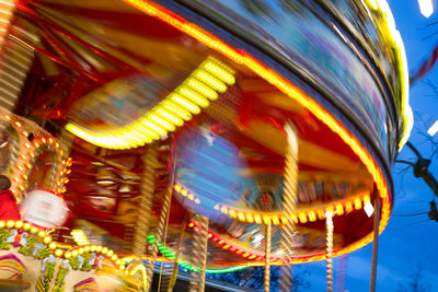 Close-up of illuminated ferris wheel against sky at night