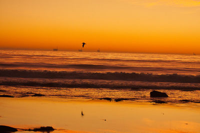 Scenic view of sea against orange sky