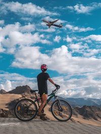 Man riding bicycle against sky