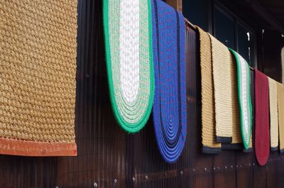 Close-up of doormats hanging for sale at market