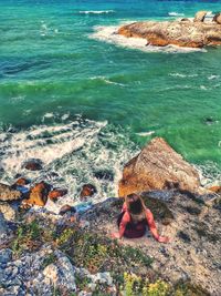 High angle view of woman on rock at beach