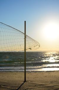 Volleyball net on beach during sunset