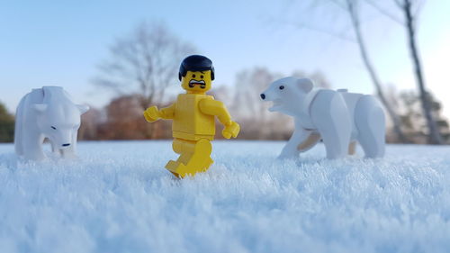 Toys on field against sky during winter
