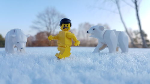 Toys on field against sky during winter