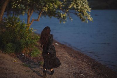 Rear view of woman walking on shore