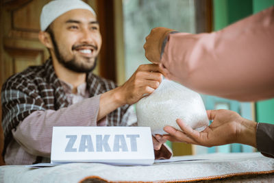 Man helping with bag of rice in mosque